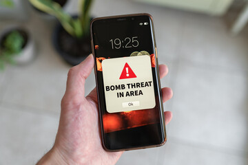 Bomb threat urgent notification on smartphone.