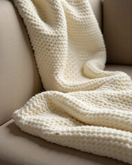 Neatly folded knitted blanket placed indoors, symbolizing warmth, comfort, coziness, and minimalist home decor