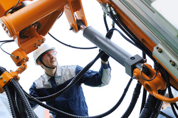 Male engineer inspecting hydraulic hoses of heavy machinery in mining industry