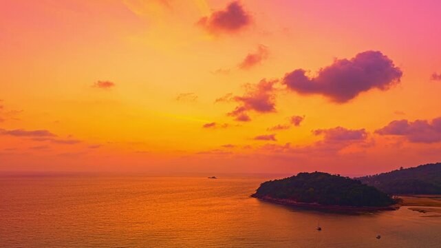 Aerial hyper lapse view of A stunning seascape capturing the vibrant colors of a dramatic sunset sky over a calm beach, Picturesque Tropical Sky at Sunset at Kala island Layan beach Phuket