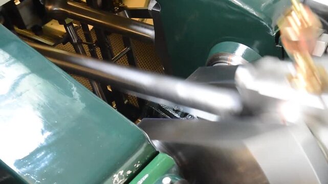 Engine room of a vintage steam boat in Switzerland, showing polished green metal parts, brass fittings, and mechanical detail in motion