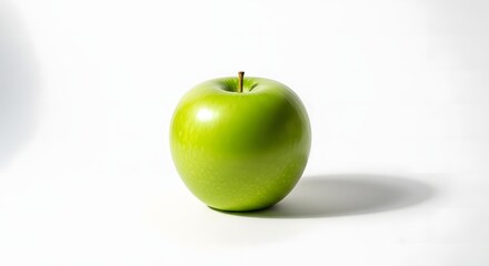 A single, ripe, green apple with a stem, casting a soft shadow on a white surface.