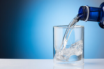 Water pouring from water bottle to glass