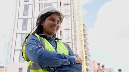Confident construction worker smiling proudly at building site during sunny day