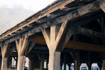 Obraz premium France, Crémieu - Intricate Wooden Beams and Posts of an Aged Covered Structure Showcasing Traditional Craftsmanship