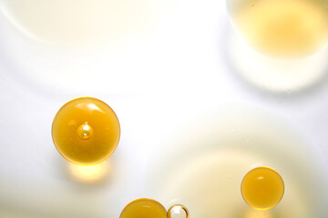 Yellow Droplets on White Background with Circular Shapes and Shadows