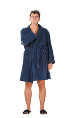 Full length portrait of sleepy young man with messy hair, wearing bathrobe, yawning and covering his mouth with palm, isolated on transparent background