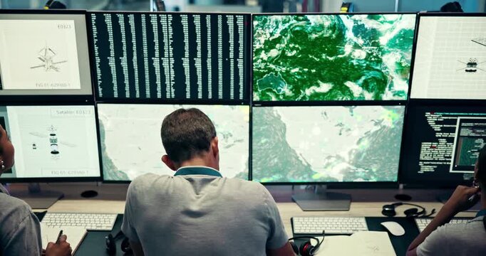 People, computer and screen for notes in control room to monitor weather, climate change and report. Staff, information and online for satellite update, study storm pattern and disaster surveillance