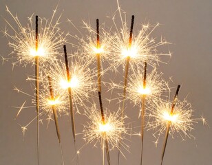 Obraz premium Sparkling sparklers against a neutral backdrop
