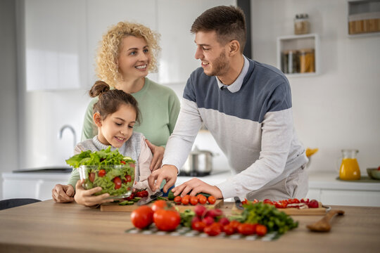 Family cooking together in a modern kitchen, preparing fresh vegetables and enjoying quality time