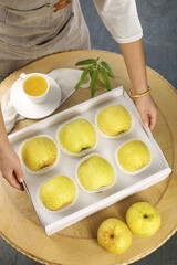 Fresh Crown Pears in White Box on Wooden Table with Tea Cup and Hands