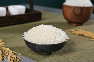 Long Grain White Rice in Bowl with Agricultural Products on Rustic Table
