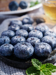 Fresh Blueberries with Water Droplets in Wooden Bowl with Mint Garnish