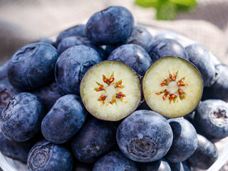 Fresh Alpine Blueberries with Cut Berry Showing Seeds - Healthy Organic Superfruit in Glass Bowl
