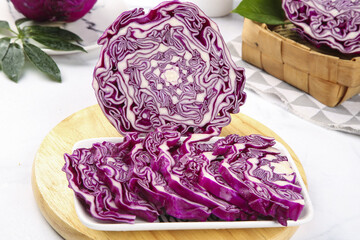 Obraz premium Purple Cabbage Sliced on Cutting Board with Fresh Collard Greens and Kitchen Vegetables