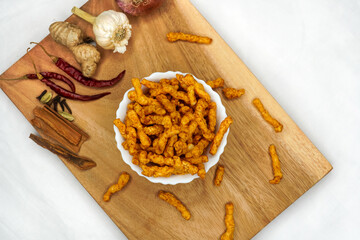 Bowl of home made potato chips made with rice, mustard, rosemary, fleur, salt, onion and chili on white background. Indian tea snacks, namkeen concepts. Top view. Copy space