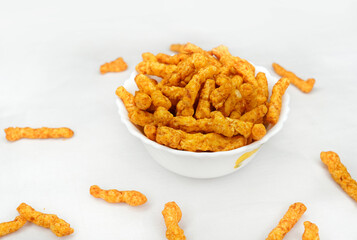 Delicious India favorite snack kurkure crunchy corn sticks, on white background. Indian tea snacks concepts.