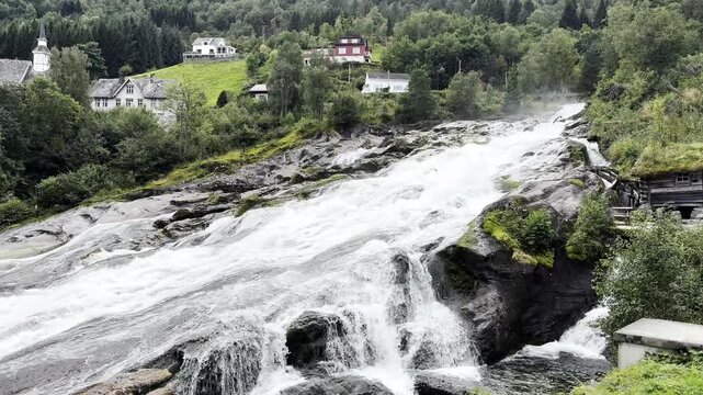 Waterfall in the village of Hellesylt Norway and houses 