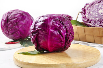 Obraz premium Fresh Purple Red Cabbage Heads on Wooden Cutting Board Kitchen Preparation