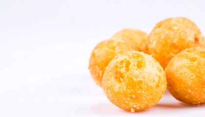 Close-up view of several golden-brown, round, crispy treats against a plain white background.