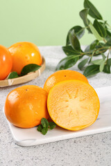 Fresh Crisp Persimmon Fruits with Sweet Orange Flesh on Marble Kitchen Counter