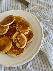 Warm homemade pancakes served on a plate. Cozy and delicious treat for a comforting home meal.