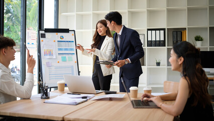 Colleagues presenting graphs and charts during a team strategy meeting.