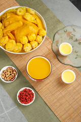 Golden chicken soup with vegetables and traditional herbal ingredients on bamboo mat