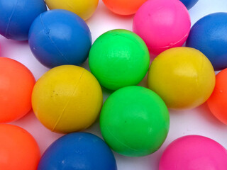 A group of colorful plastic balls. The balls come in different colors, including red, green, yellow, blue, and pink. The concept of joy and fun.