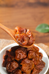 Gaozhou Dried Cinnamon Flavored Lychee on Wooden Spoon - Traditional Chinese Preserved Fruit Specialty