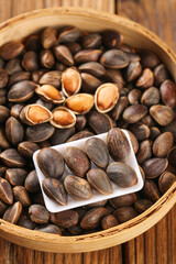 Freshly Harvested Wild Pine Nuts in Wooden Bowl with Natural Shells and Golden Kernels