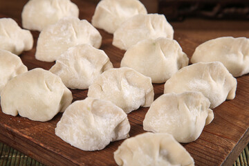 Traditional handmade Spanish mackerel seafood dumplings on wooden board ready for steaming