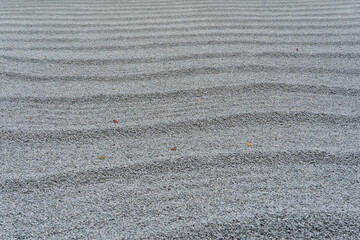 Japanese Zen Garden Gravel with Ripple Patterns.Raked Gravel in Traditional Japanese Rock Garden.White Gravel Texture in Zen Garden.Stone Garden with Wave Patterned Sand.Japanese Rock Garden Gravel