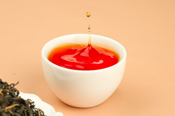 Chinese Black Tea Drop Splash in White Cup with Loose Tea Leaves Yunnan Dahongpao Style
