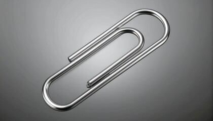 Polished metal paperclip on a gray background