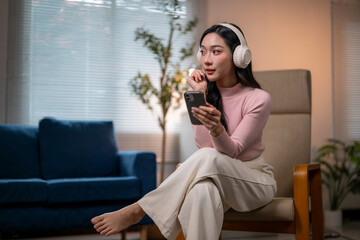 Young woman listening music with wireless headphones and smartphone at home