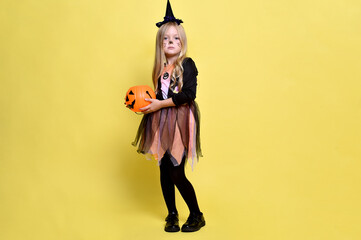Little girl with blonde hair in a witch costume with a candy cane for Halloween