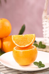 Fresh Orange Slice on White Plate with Mint Garnish - Healthy Citrus Fruit Concept