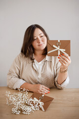 woman presents gift certificate envelope with seal and bow