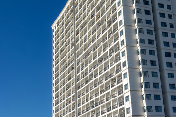 Obraz premium Tall modern apartment building against clear blue sky