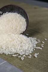 White Rice Grains Spilling from Bowl on Burlap - Raw Uncooked Food Ingredient