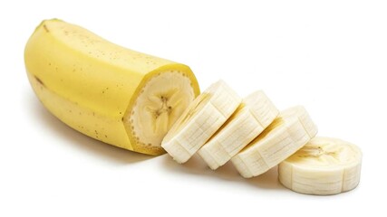 A yellow banana partially peeled and sliced into rounds displayed on a white surface - Powered by Adobe