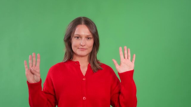 Woman shows different hand signs  the number nine against a green background while wearing a red shirt, expressing various counts during a casual activity session