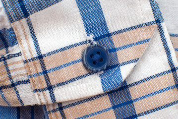 Men's shirt. Plaid shirt sleeve with buttons. Piece of clothing. Button