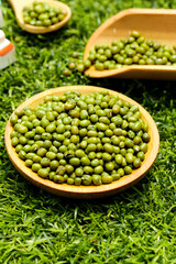 Fresh Organic Mung Beans in Wooden Bowls on Green Grass Meadow Background