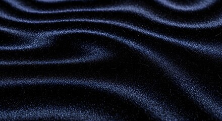Close up of dark blue velvet fabric with flowing waves and subtle highlights