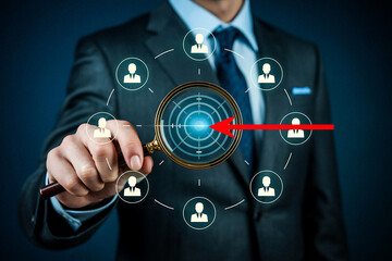 Businessman focuses on target with magnifying glass and network of people icons