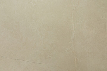 Light beige marble surface with subtle veins and texture under bright lighting showcasing natural patterns and elegance in interior design