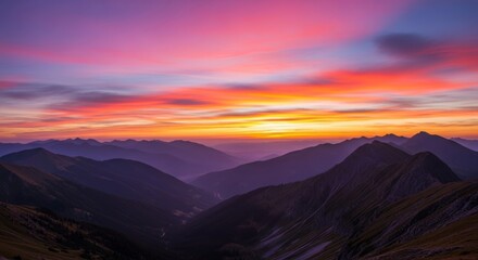 A breathtaking sunset over a mountain range. The sky is filled with vibrant colors of pink, orange, and purple. Silhouettes of peaks create a dramatic landscape.