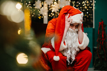 Stressed santa claus touching head near christmas tree